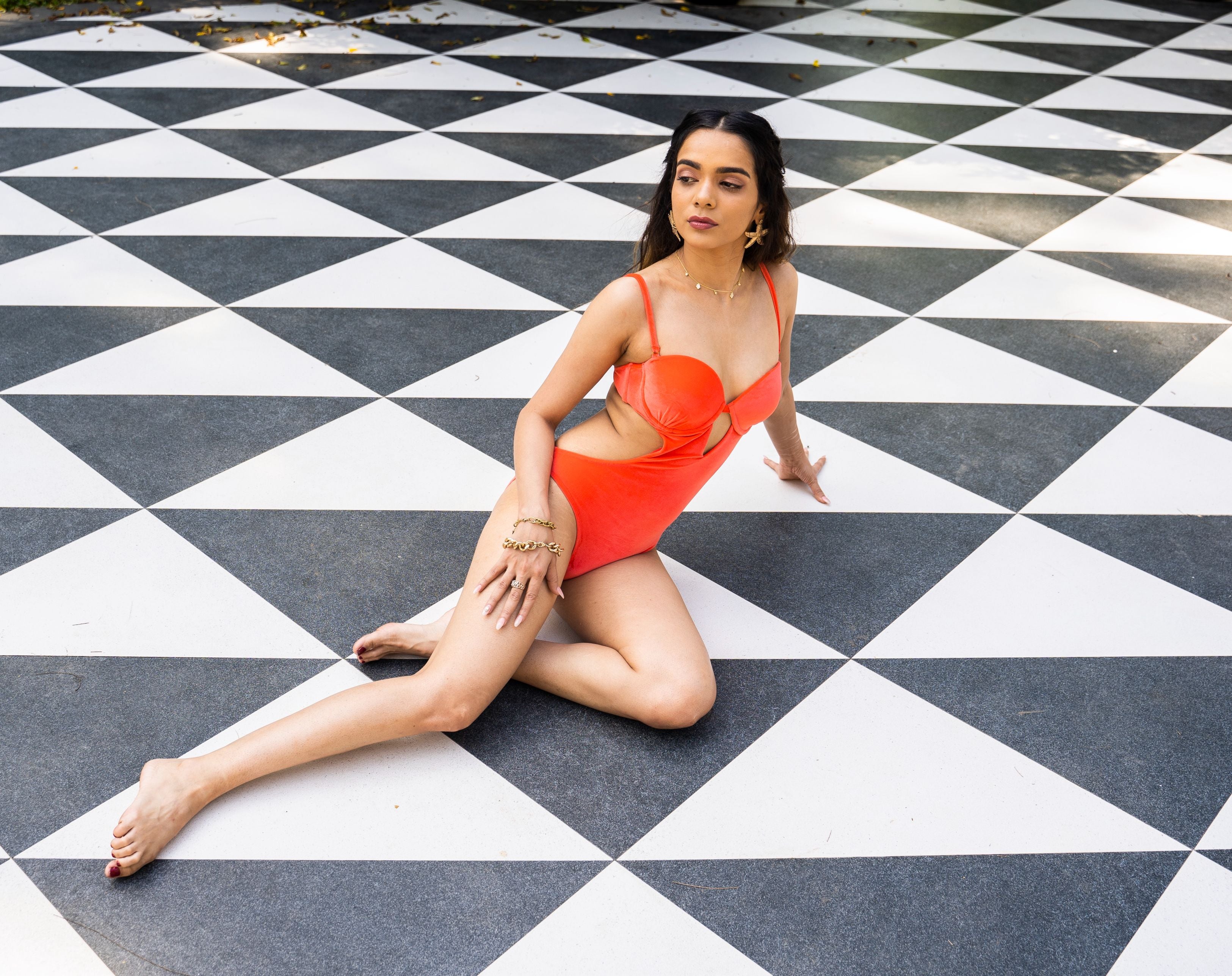 Designer Starfire one-piece swimsuit for women in orange, navy blue and purple with side cut-outs, underwire, in- built cups and an open back with a gold clasp. Customizable, stylish swimwear for sexy summer looks.