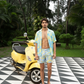 Model wearing Bergamo shorts for men in blue tropical print, styled as designer beachwear and stylish summer wear for men.